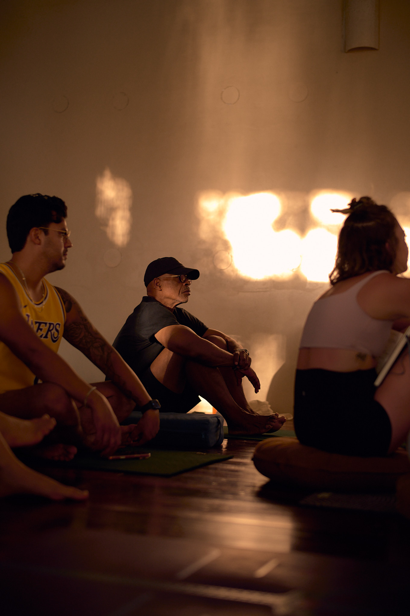 Students gather in seated circle at golden hour for a quiet teaching session inside the shala.