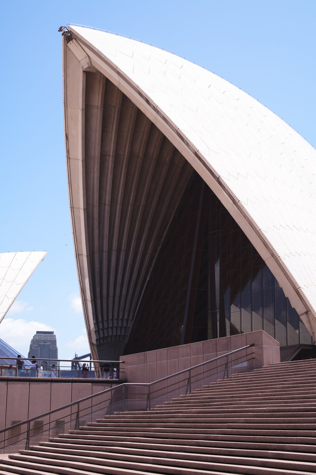 Close study of the white tiled sails of the Sydney Opera House against a clear sky.