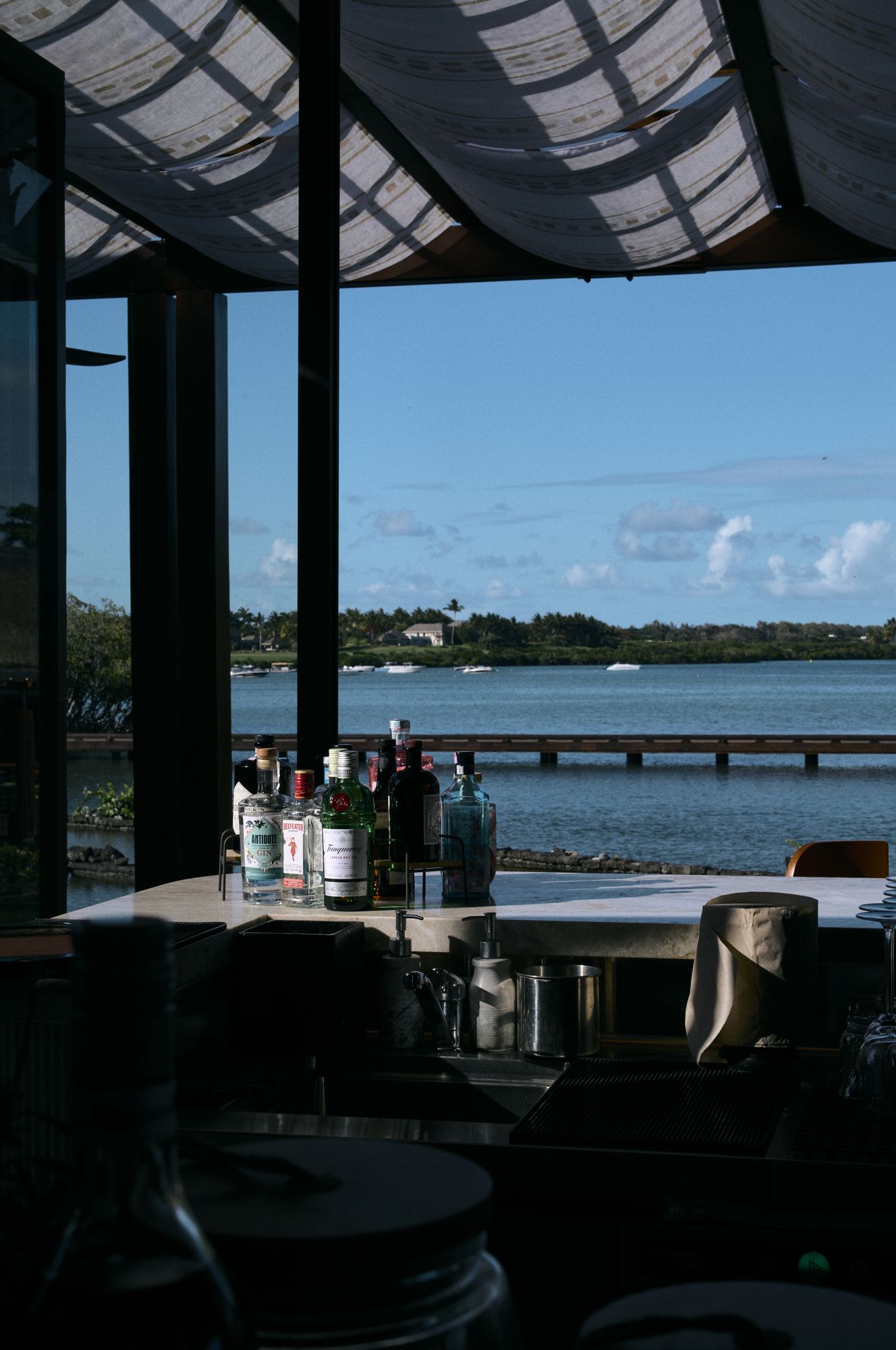 A restaurant interior opening onto the sea through full-height windows, Mauritius.